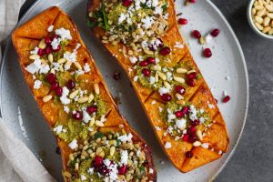 Vegetarian roasted butternut squash with pistachio pesto, grains, pine nuts, pomegranate and feta. A delicious fall recipe, perfect vegetarian Thanksgiving recipe.