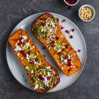 Vegetarian roasted butternut squash with pistachio pesto, grains, pine nuts, pomegranate and feta. A delicious fall recipe, perfect vegetarian Thanksgiving recipe.