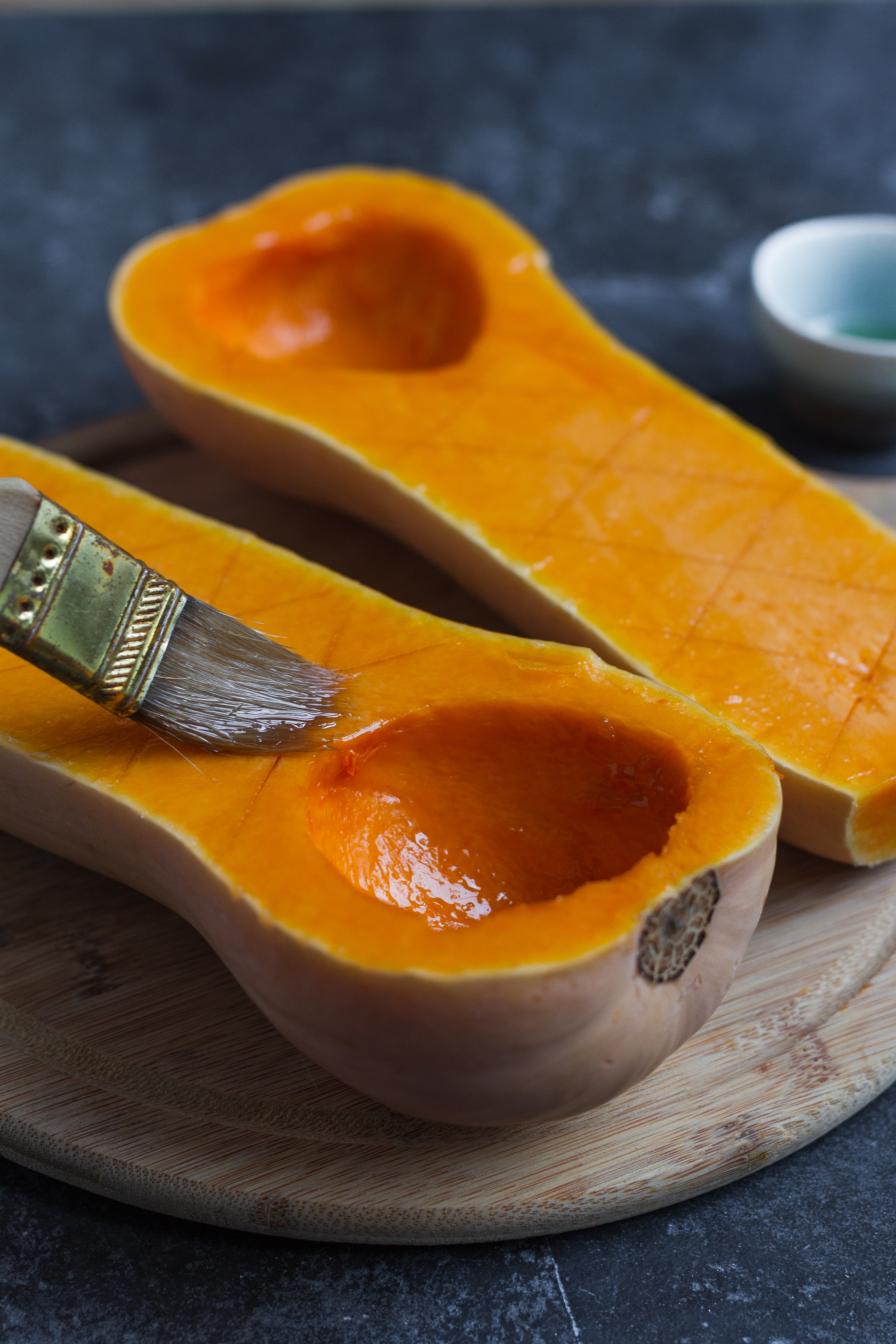 brushing butternut squash with oil for roasting