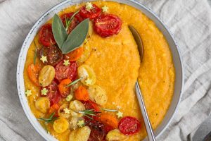 herby butternut squash polenta topped with roasted tomatoes and avocado